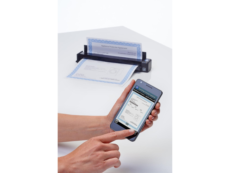 A person scans a document using a mobile phone and scanner