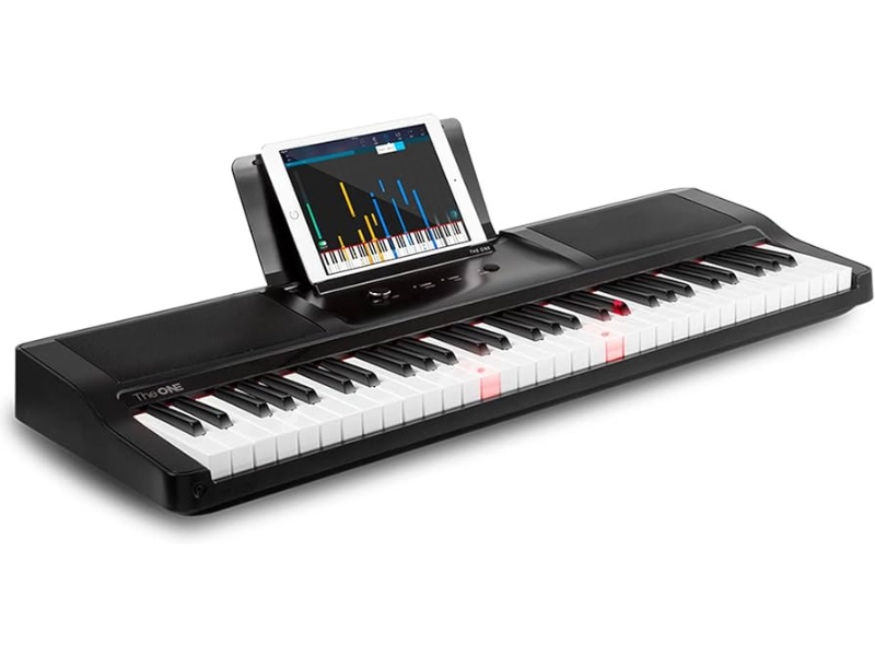 Digital piano with illuminated keys and tablet displaying music app