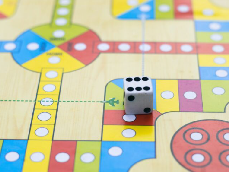 A close-up of a board game with a die on it