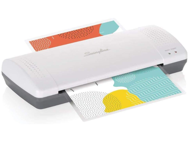 A laminator with colorful patterned sheets partially inserted