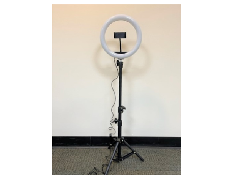 A standing ring light with a smartphone holder attached