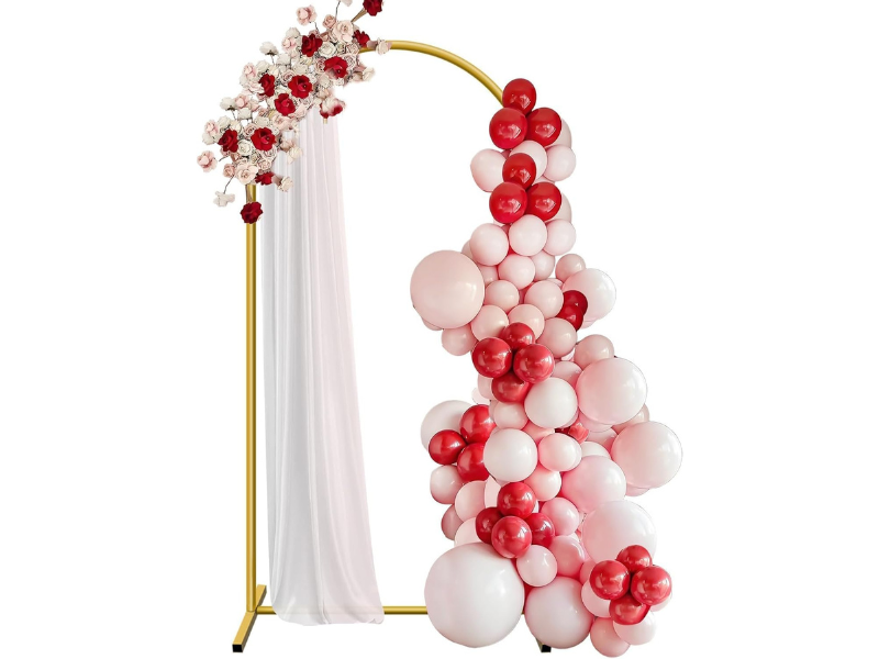 Gold arch adorned with pink and red balloons and flowers